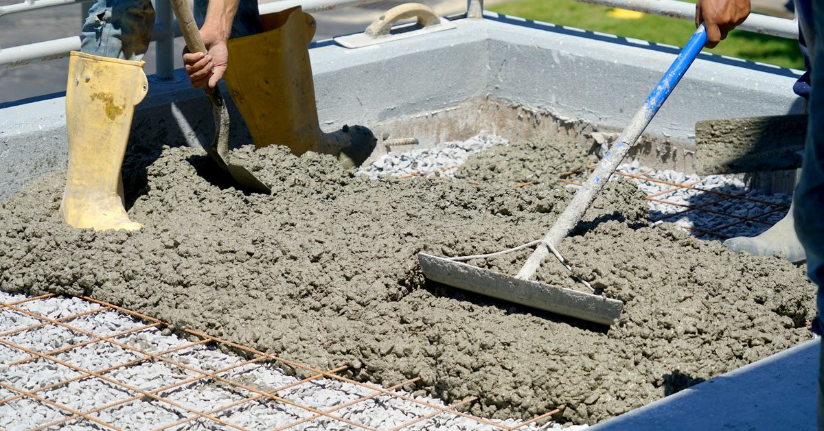 Worker powering cement in the driveway construction site